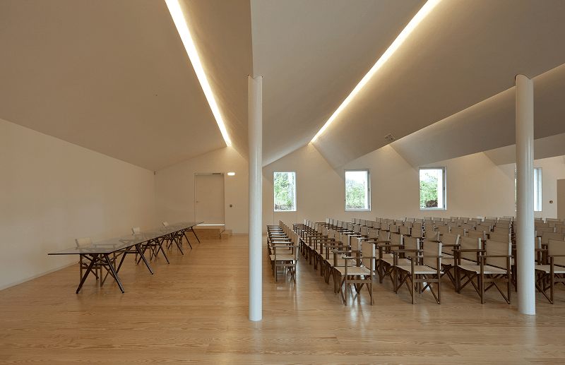 Platzhalter: Lichtdurchfluteter Veranstaltungssaal mit hoher Decke und Bestuhlung in Reihen